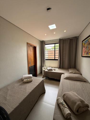 a bedroom with two beds and a window at Pousada Cobogó - MotoWeek, ANP in Brasília