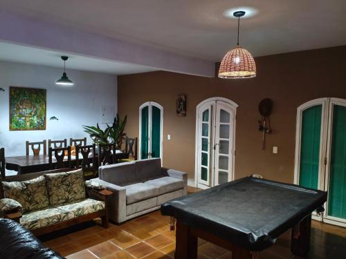 a living room with a couch and a pool table at Chácara Palma in Ubatuba