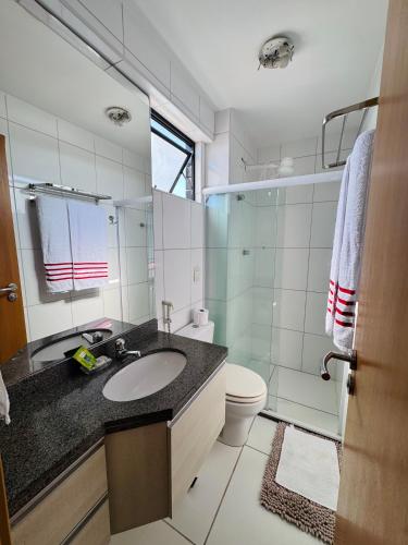 a bathroom with a sink and a toilet and a shower at Lindo APTO na Ponta Verde in Maceió