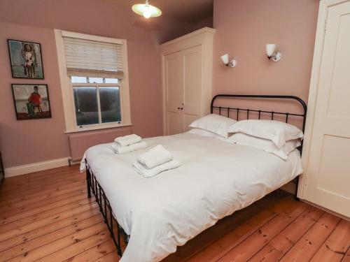 a bedroom with a bed with white sheets and pillows at Armstrong Cottages No6 in Bamburgh