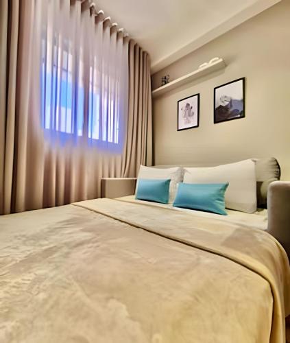 a bedroom with a large bed with blue pillows at Studio Prime, no centro de CWB in Curitiba