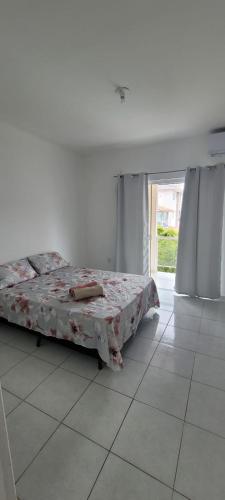 a bedroom with a bed and a tiled floor at Casa Confort Praia dos Ingleses in Florianópolis