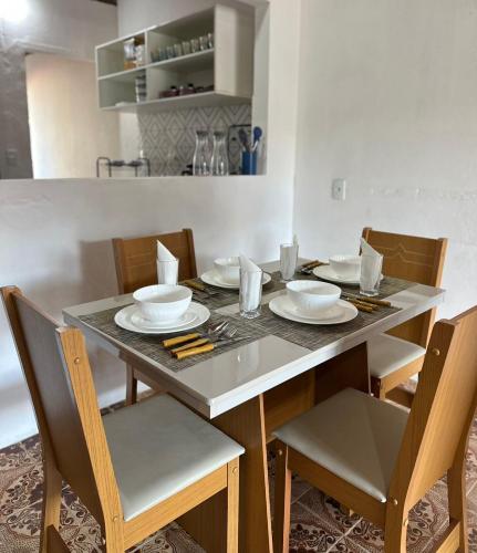 a dining room table with chairs and plates on it at CASA MARAGOGI 3 Quartos in Maragogi