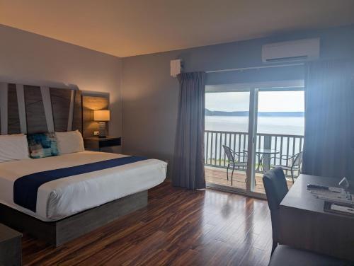 a hotel room with a bed and a balcony at The Waterfront at Potlatch in Shelton