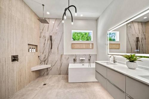a bathroom with a tub and a sink and a mirror at Waldemere's Wonderland in Sarasota