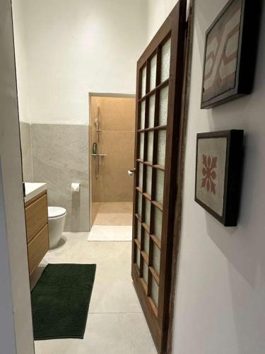 a bathroom with a shower and a toilet and a door at The Hidden Mint - Valletta in Valletta