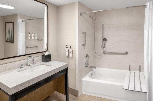 a bathroom with a tub and a sink and a shower at Embassy Suites San Antonio Riverwalk-Downtown in San Antonio