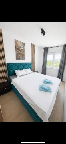 a bedroom with a bed with two towels on it at RIVER LuX in Veliko Gradište