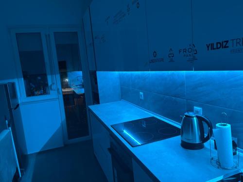 a kitchen with a stove top in a blue light at Capital Gate Guest House in Skopje