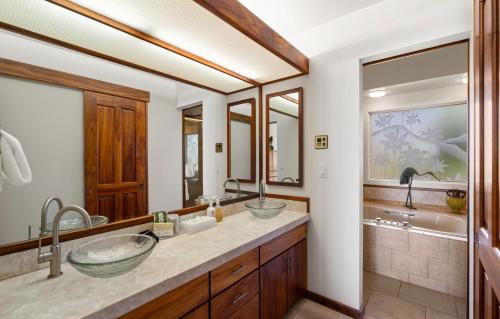 a bathroom with two sinks and a tub at Puunoa Beach Estate in Lahaina