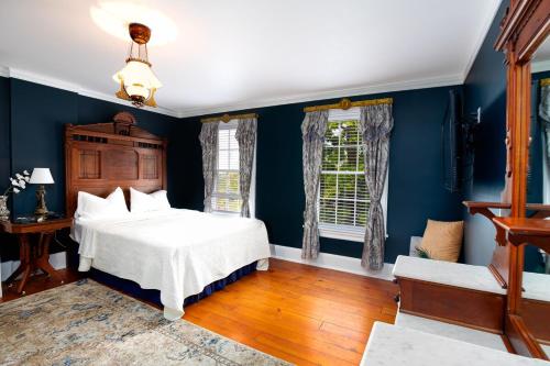 a bedroom with blue walls and a bed and a window at US Grant Guest House in Galena