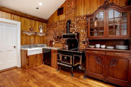 a kitchen with an old fashioned stove and brick wall at US Grant Guest House in Galena