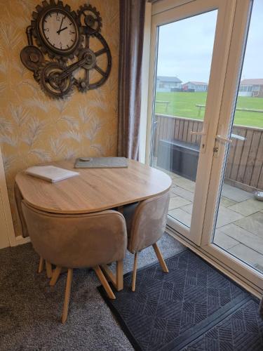 a desk with a clock on the wall next to a window at Pet friendly sleeps 6 Chalet Bridlington free elec in Bridlington