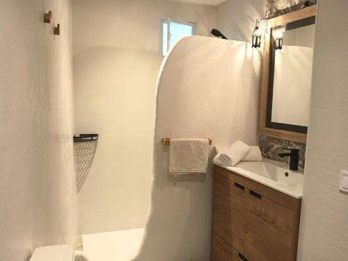 a bathroom with a sink and a toilet and a mirror at Villas con piscina en Punta Umbría by Villamya in Punta Umbría