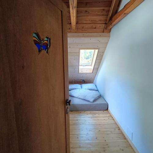 a small bedroom in a tiny house with a bed at Całoroczny dom nad Jeziorem Rożnowskim in Gródek Nad Dunajcem