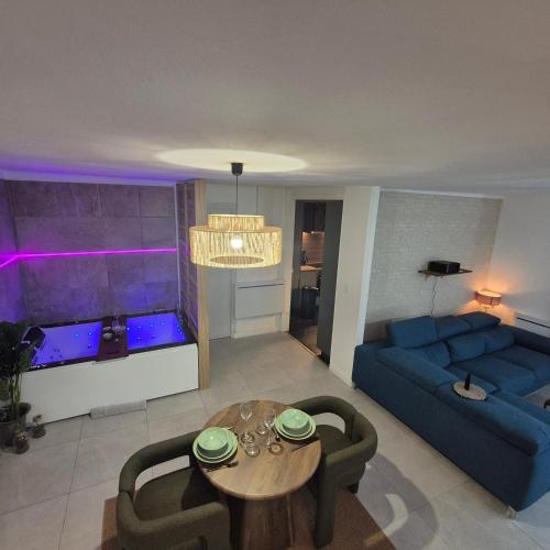 a living room with a blue couch and a table at LoveRoom La Parenthèse Secrète in Lampaul-Plouarzel