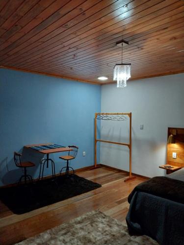 a room with a table and chairs and a ceiling at Chalé Vila do Vento in Lavras Novas