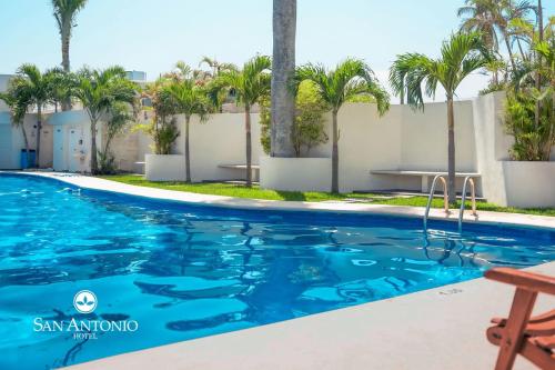 a swimming pool at a resort with palm trees at Hotel San Antonio in Tampico
