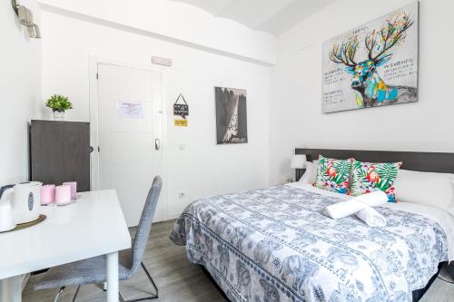 a bedroom with a bed and a table and a desk at AYZ Juan de Mena - Auto check-in property in Madrid