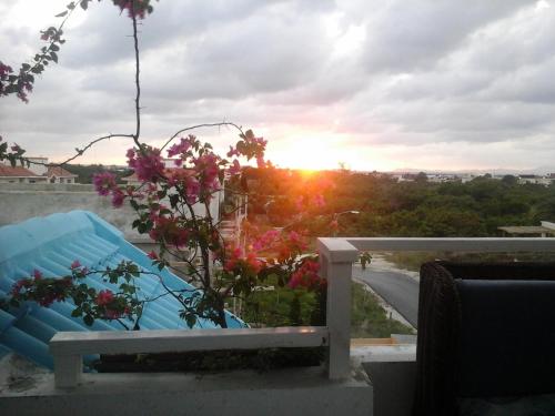 a bench on a balcony with the sunset in the background at Nely y Pietro share apartment in Punta Cana