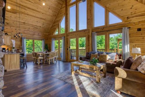 a living room and kitchen in a log cabin at Ridge Hollow Retreat - Hot Tub, Fire Pit, Dogs in Gatlinburg