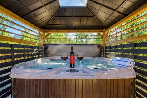 a hot tub with two glasses of wine in it at Ridge Hollow Retreat - Hot Tub, Fire Pit, Dogs in Gatlinburg