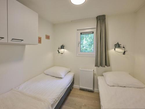 two beds in a room with a window at Steltloper in Nunspeet