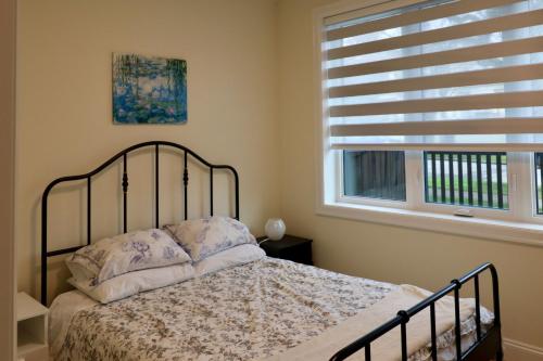 a bedroom with a bed and a window at SixPine - One bedroom suite in Vancouver