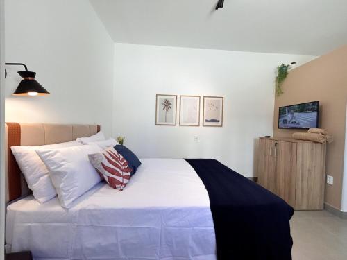 a bedroom with a large white bed with pillows at AP Smart Samaritan Fast Internet Office in Campinas