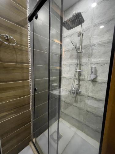 a bathroom with a shower with a glass door at Pyramids Sunshine Hotel in Cairo