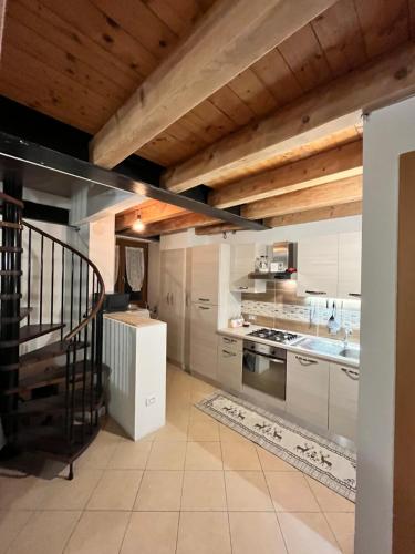 a kitchen with white appliances and a wooden ceiling at BORMIO Alpine Suite in Valdidentro