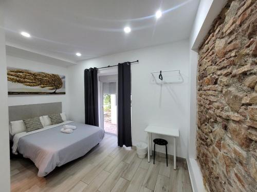 a bedroom with a bed and a stone wall at AYZ Silvela - Auto check-in property in Málaga
