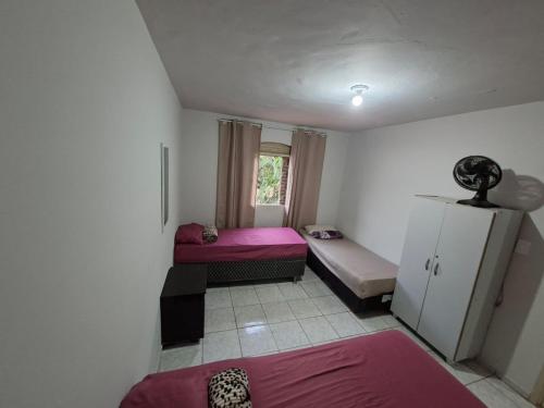 a small room with two beds and a couch at Hostel Repou-Z in Goiânia