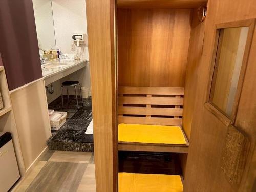 a small room with a yellow bench in a bathroom at ホテルスター in Iwaki