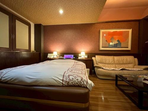 a bedroom with a bed and a couch at ホテルスター in Iwaki