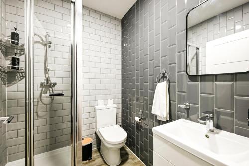 a bathroom with a toilet and a sink at Bright & Modern Apartment in Hackney Wick E3 in London