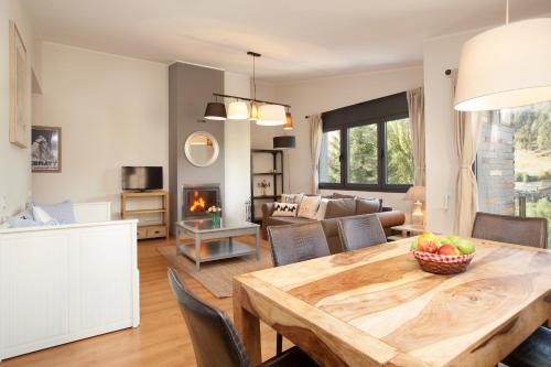 a kitchen and living room with a table and a couch at Tarter Mountain Suites in El Tarter