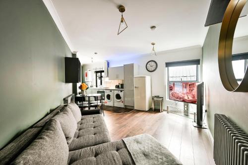 a living room with a couch and a kitchen at Bright & Modern Apartment in Hackney Wick E3 in London