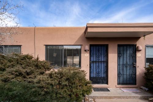 a pink house with black doors and windows at Casita De Alces in Santa Fe