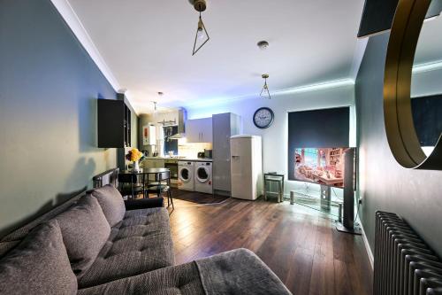 a living room with a couch and a kitchen at Bright & Modern Apartment in Hackney Wick E3 in London