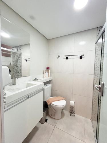 a white bathroom with a toilet and a sink at AP Smart Center in Campinas
