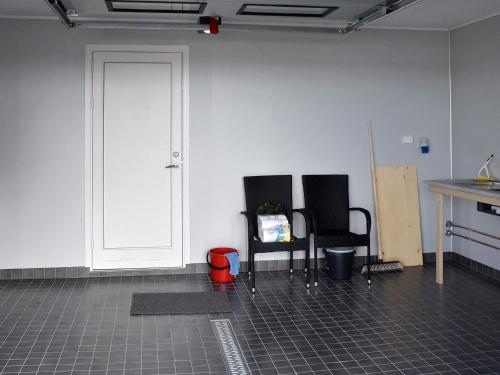 two black chairs sitting in a room with a door at 6 person holiday home in Dyrvik in Dyrvik