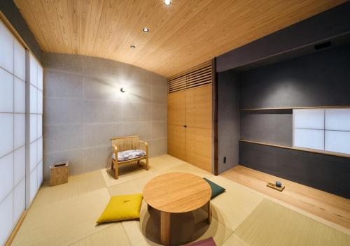 a room with a wooden table and a chair at Cortile in Mitoyo