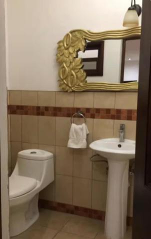 a bathroom with a toilet and a sink and a mirror at Nico Hotel in Antigua Guatemala