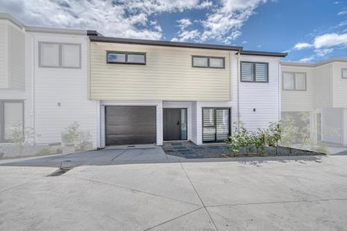 a large white house with a garage at Boutique Hillside Heaven near AKLD Airport in Auckland