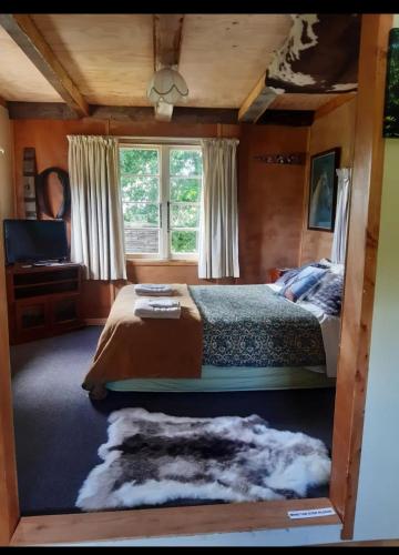 a bedroom with a large bed and a window at Edens retreat in Upper Moutere