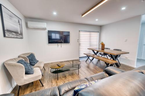 a living room with a couch and a table at Boutique Hillside Heaven near AKLD Airport in Auckland