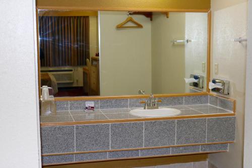 a bathroom with a sink and a mirror at Budget Inn in Barstow