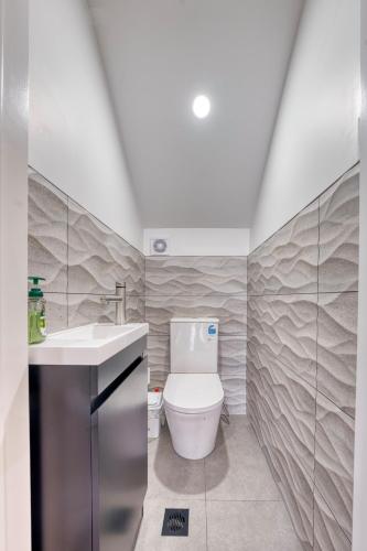 a bathroom with a toilet and a sink at Boutique Hillside Heaven near AKLD Airport in Auckland