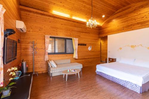 a bedroom with a bed and a couch in a room at Walk Cloud Bed and Breakfast in Meishan